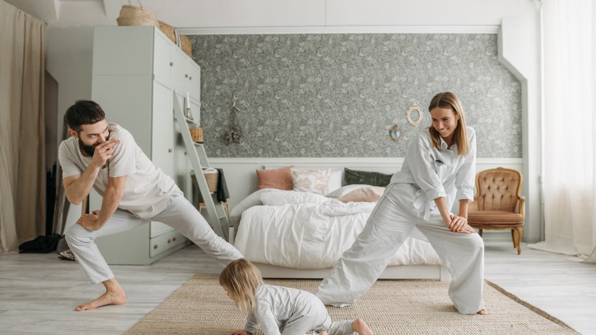 A joyful family bonding through morning stretches in a cozy bedroom setting.